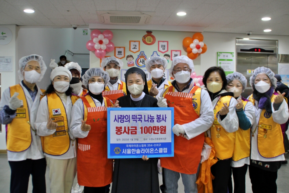 서울 한솔 라이온스 클럽 회원들이 복지관의 2023 설빔 나눔 행사에 참여하고 기념사진을 찍고 있습니다.